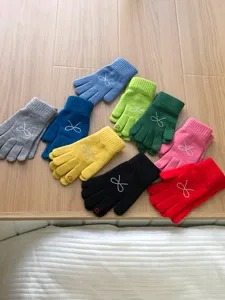 Colorful knit gloves for women with rhinestone bow. Warm winter accessories in multi colors.