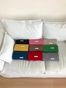 Multicolor woolen scarf set neatly displayed on sofa, cozy winter warm fashion accessory.