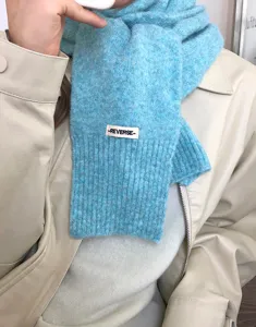 Blauer Strickschal Detail, kuscheliger Winter Woll Halswärmer mit Label, weiche Stoff Textur.