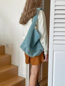Cozy blue fuzzy tote bag detail worn on shoulder, showing soft texture and large capacity.
