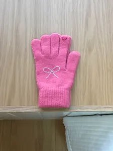 Cute pink knit gloves for women featuring rhinestone bow detail and soft winter wool texture.