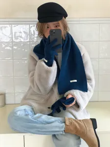 Cozy winter wool scarf and knit gloves set, stylish chic outerwear pairing for cold weather warmth.