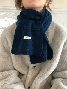 Detailed view of the dark blue knit wool scarf with soft texture and cozy winter styling.