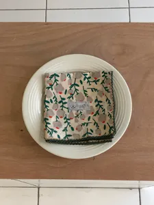 Nahaufnahme eines ländlichen Baumwoll-Leinen-Quadrat-Halstuchs mit Blumenmuster auf Teller.