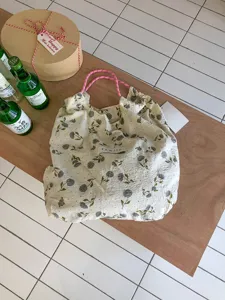 Blumen-Tragetasche mit rosa Kordelzügen, lässiger, süßer Picknick-Urlaubsstil für Damen.