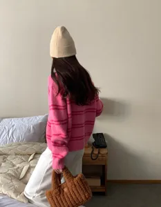 Détail de bonnet en tricot beige douillet dans une ambiance de chambre chaleureuse en hiver.