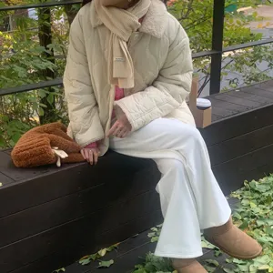 Vue détaillée d'écharpe d'hiver et de veste matelassée, style de saison confortable.