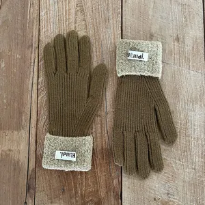 Gedetailleerd overzicht van bruine gebreide winterhandschoenen met pluche boorden en labels.