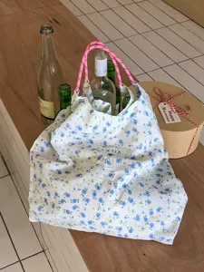 Schicke florale Tragetasche aus Stoff mit pinken Kordelgriffen, stilvolle ästhetische Damentasche.