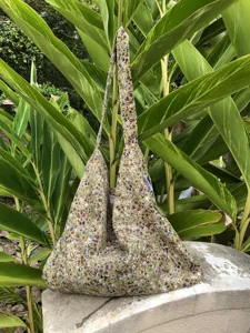 Casual floral canvas shoulder bag detail, lazy style tote bag with green botanical backdrop.