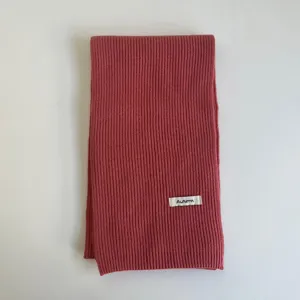Écharpe d'hiver en tricot douillet couleur rose poussiéreux avec texture côtelée douce.