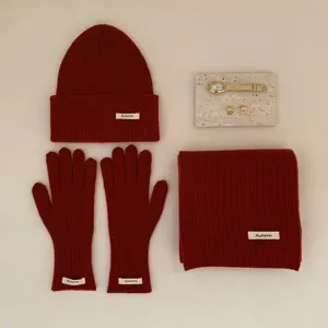 Vue détaillée d'un ensemble hivernal rouge bonnet gants et écharpe avec étiquette d'automne.
