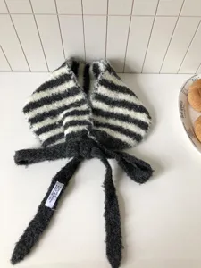 Winter schwarz-weiße gestreifte Plüsch Ohrenschützer mit süßen Bändern im feinen Detail.