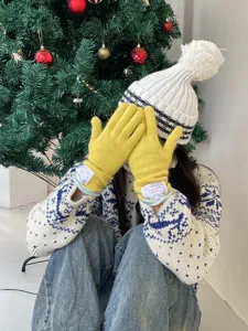 Vue détaillée de gants d'hiver tricotés jaunes douillets avec étiquette et texture douce.