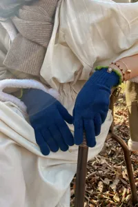 Detailed view of women's touchscreen knit gloves with contrast green frilly cuffs for winter warmth.