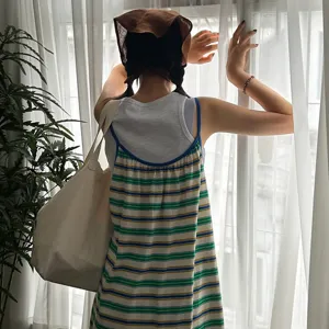 Dettaglio di un foulard triangolare in cotone e lino indossato in una comoda stanza luminosa.