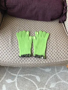 Green knitted touch screen gloves for women with cute ruffles and finger embroidery.