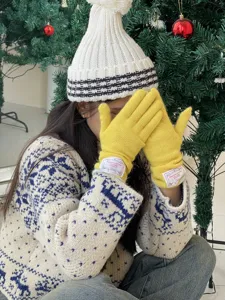 Gros plan détaillé de gants en tricot jaune pour femmes avec un bonnet d'hiver.