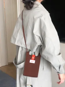 Vista detallada del bolso cruzado para teléfono de punto marrón con estilo coreano elegante.