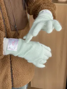 Vue détaillée de longs gants d'hiver en tricot de poil de lapin vert pastel bien chaud.