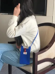 Mini bolso bandolera de punto azul para móvil en detalle, accesorio de moda elegante.