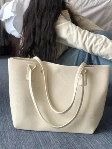Vue détaillée du sac cabas en tricot minimaliste montrant le tissu texturé et les bretelles.