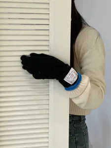Vue détaillée de gants longs en tricot de poils de lapin avec étiquette et bordure bleue.