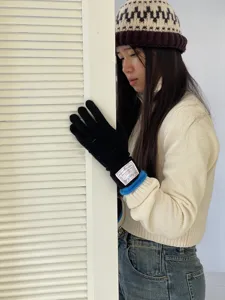 Gants en tricot noir pour femmes, design long avec poignet bleu et étiquette blanche chic.