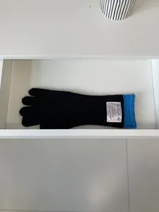 Gants d'hiver longs en tricot noir avec des poignets bleus contrastés et une étiquette.
