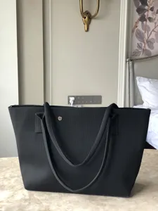 Grand sac cabas tricoté noir, sac à épaule minimaliste élégant avec anses solides.
