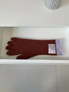 Gros plan détaillé de longs gants tricotés chauds marron avec poignet violet et étiquette.