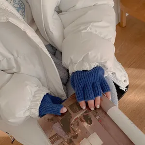 Nahaufnahme blauer Strick-Fingerlos-Handschuhe für warme Herbsttage, weiche Wollstruktur.