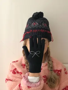 Winter women's cute black knit gloves with rhinestone bow and matching pom pom beanie hat.