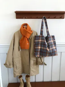 Oversized plaid wool shoulder bag for women, cozy winter tote with large capacity and chic design.