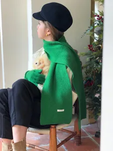 Detail view of the elegant green wool knit scarf featuring soft texture and cozy winter warmth.