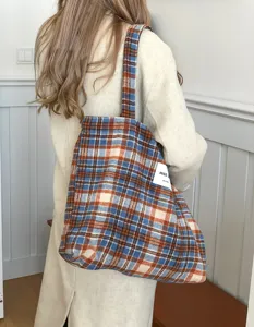 Detail shot of the cozy wool plaid tote bag showing texture and casual winter style.