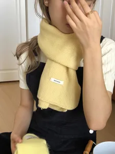Solid yellow knitted wool scarf detail showing soft texture and cozy winter warmth wear.