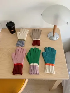 Detailed view of colorful knitted gloves showcasing winter warm fabric and stylish color block.