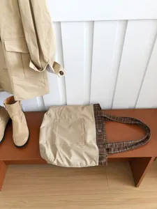 Casual khaki oversized canvas tote bag with brown plaid woolen shoulder straps for women.