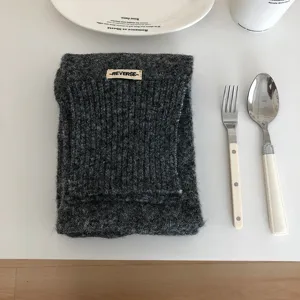 Dunkelgrauer Strickschal Detailansicht, kuschelig texturierter Wollstoff mit Webetikett.