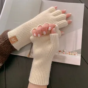Nahaufnahme von minimalistischen, beigen Strick-Fingerling-Handschuhen mit kuscheliger Textur.