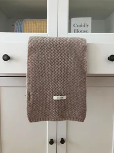 Detail view of a cozy brown 100% wool knitted scarf, soft winter warm accessory.