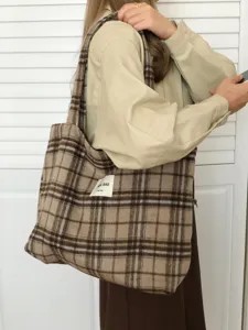 Detail view of a cozy brown plaid wool tote bag, featuring a soft winter lazy shoulder style.
