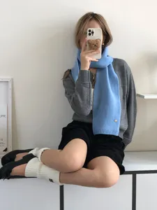 Primer plano de una elegante bufanda de punto azul claro usada por la modelo outfit.