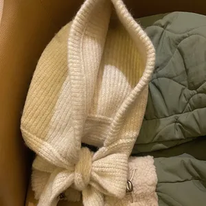 Dettaglio passamontagna in maglia, sciarpa cappuccio invernale calda con grazioso fiocco.