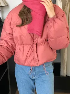 Chaqueta acolchada rosa y bufanda de punto acogedora, primer plano de estilo diario.