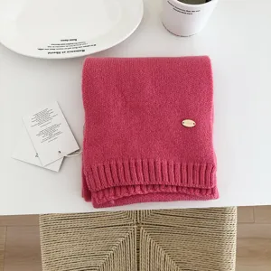 Detalle bufanda de punto rosa, textura lana cálida accesorio moda invierno para mujeres diario.