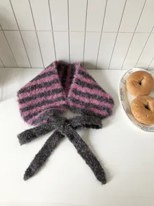 Detailansicht des flauschigen Winter-Strick-Ohrwärmers mit Streifen und Bändern, gemütlich.