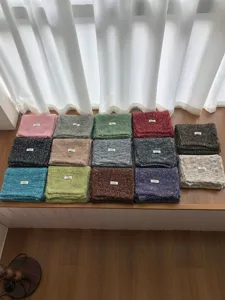 Vista dettagliata di sciarpe invernali colorate in misto lana con motivi melange vari.