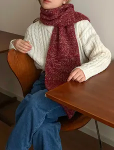 Primo piano dettagliato di una comoda sciarpa invernale in maglia mélange rossa.